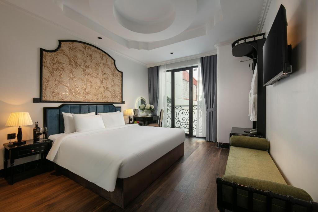a bedroom with a large white bed and a television at Phat Diem Plaza Hotel in Ninh Binh