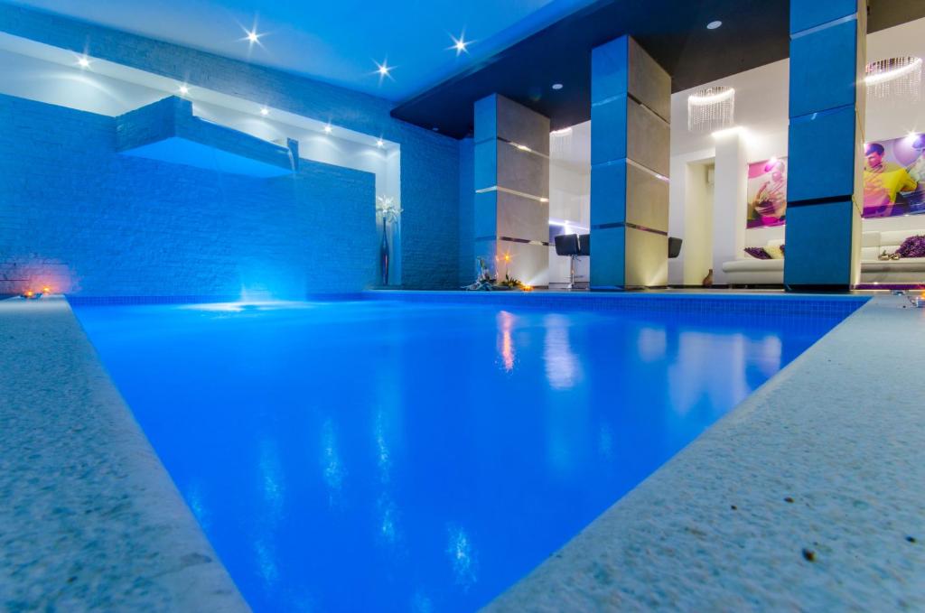 a swimming pool in a house with blue lighting at La Vela Luxury in Trogir