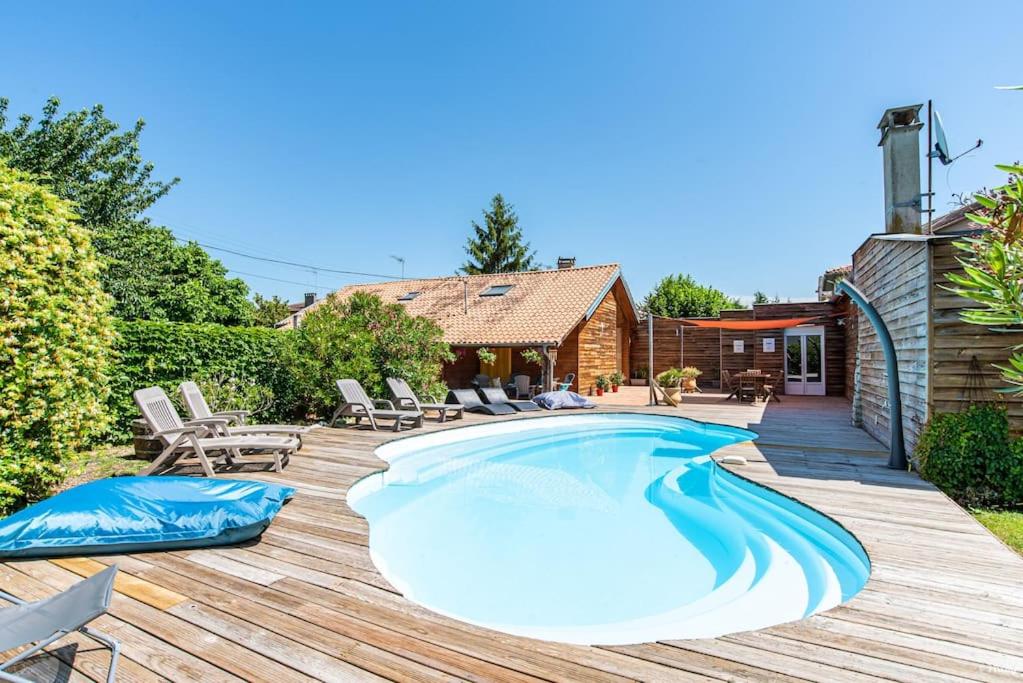 - une piscine sur une terrasse avec des chaises et une maison dans l'établissement Villa Olympe, à Montauban