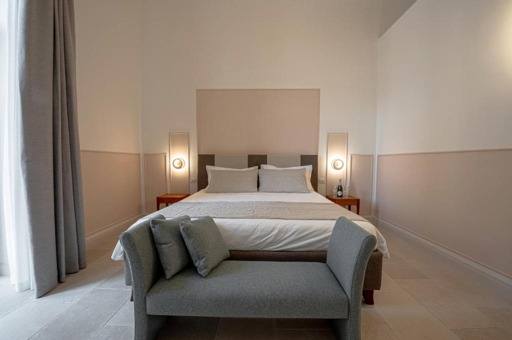 a bedroom with a large bed and a chair at Il Leccio Verde in Lecce