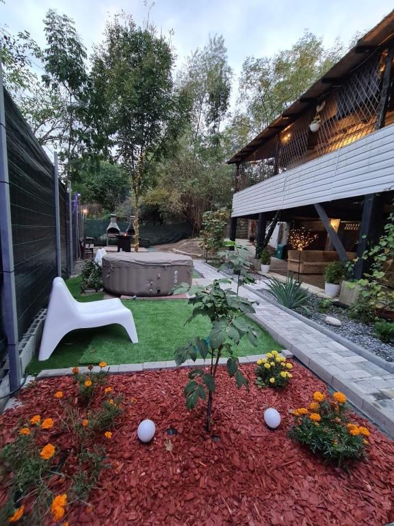un giardino con una sedia bianca e un tavolo di Vila DS - Slănic Prahova a Prăjani