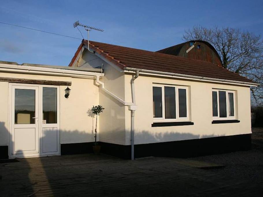 a white house with a red roof at Penlan Farm Cottage in St Clears