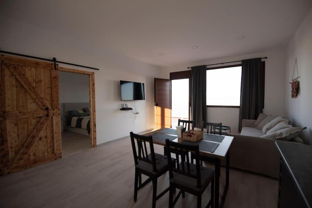 un salon avec une table et des chaises et un lit dans l'établissement Casa Teresa, à Tinajo