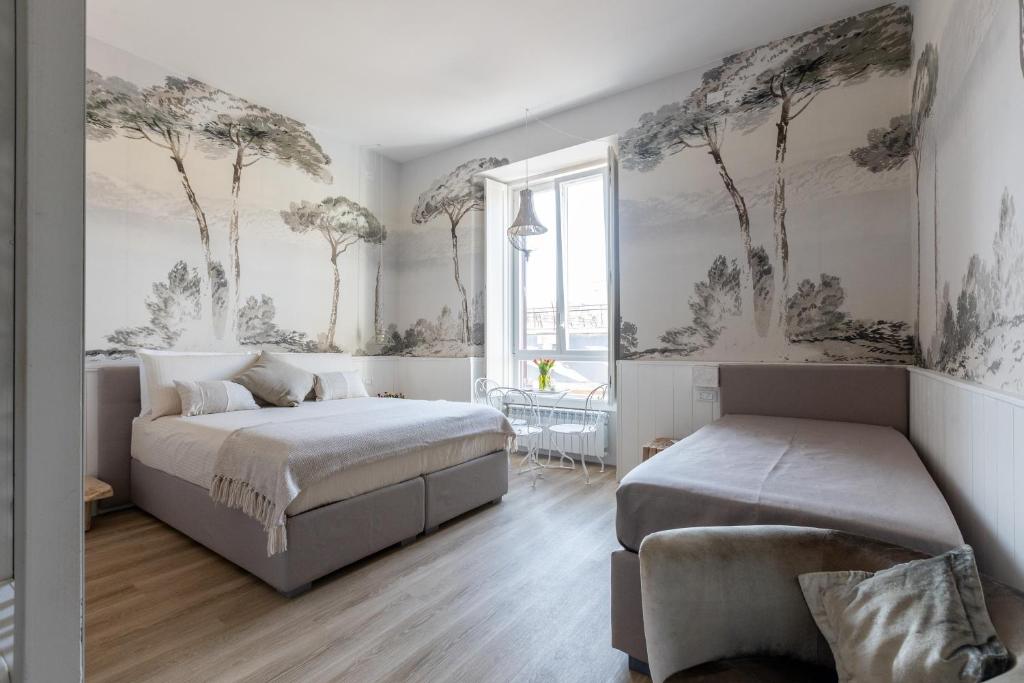a bedroom with two beds and trees on the walls at Primo Piano Suites Garden in Rome