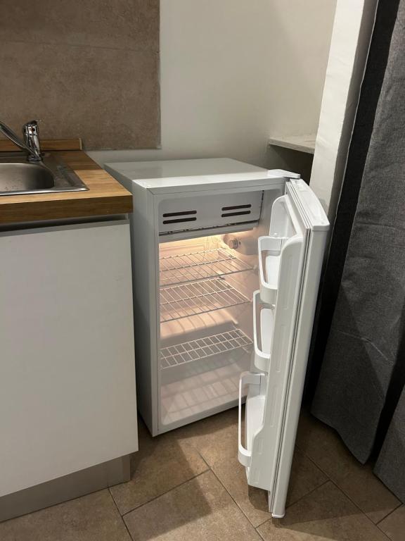 een lege koelkast met de deur open in een keuken bij Monolocale 1 in Turijn