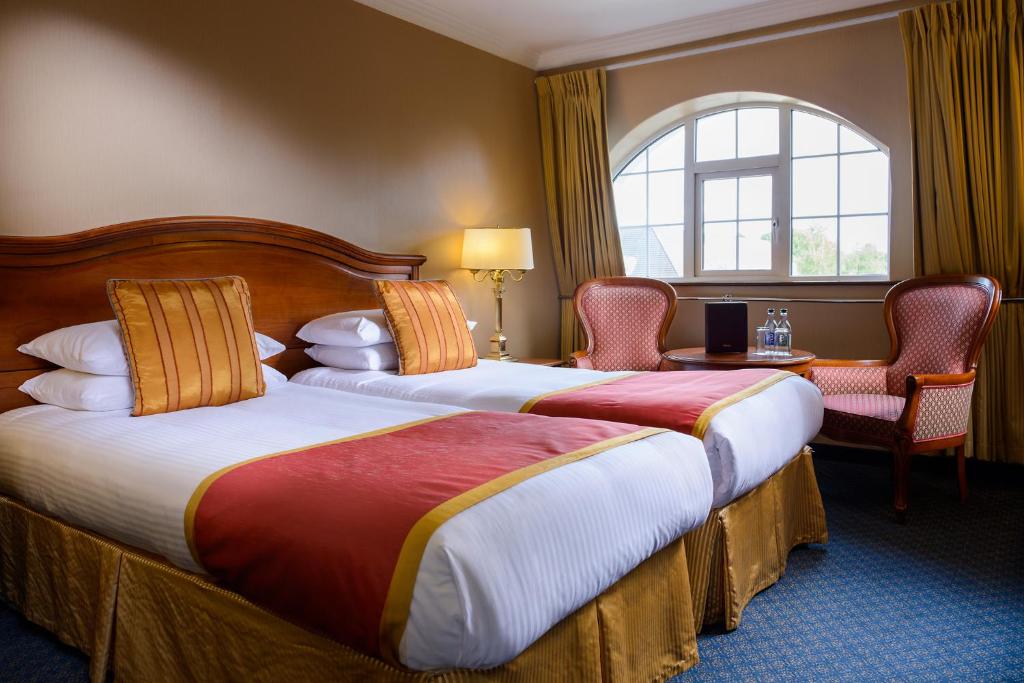 una camera d'albergo con due letti e una finestra di River Island Hotel a Castleisland