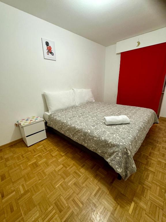 a bedroom with a bed and a red wall at La Maison de Voyage in Lausanne