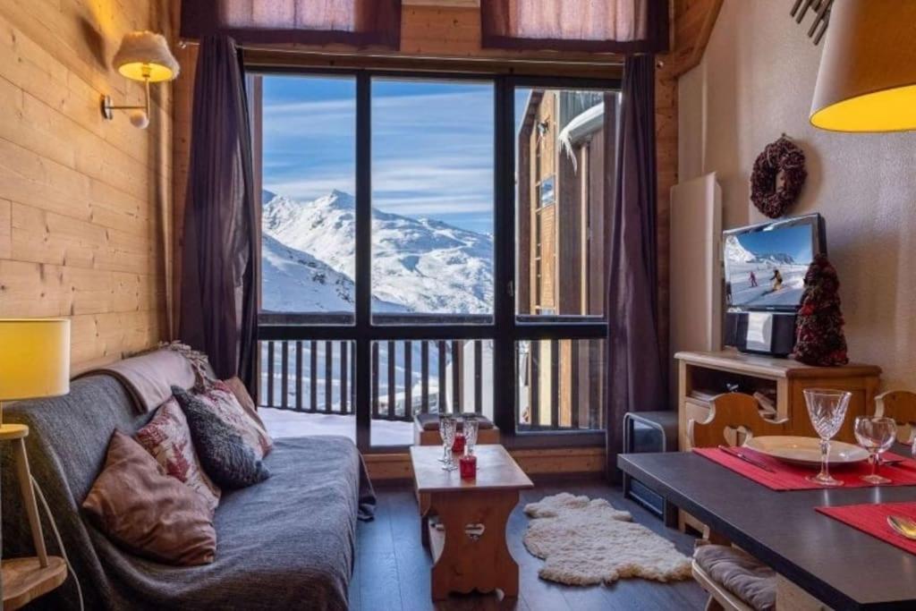 un salon avec un canapé et une grande fenêtre dans l'établissement Appartement duplex-mezzanine, à Val Thorens