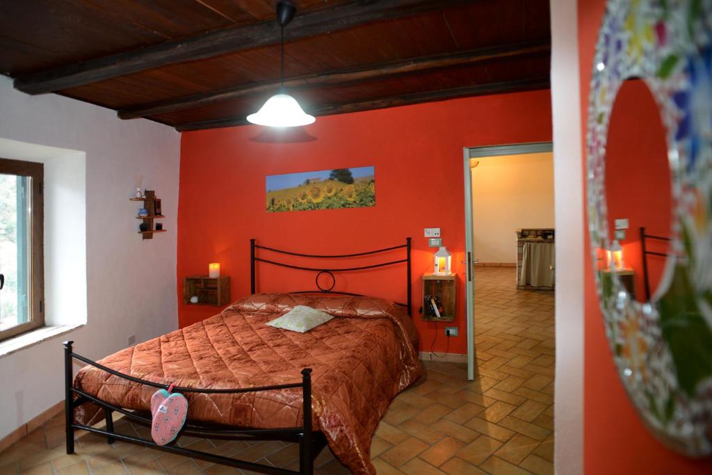 sypialnia z łóżkiem z pomarańczową ścianą w obiekcie casa Totò w mieście Mazzano Romano