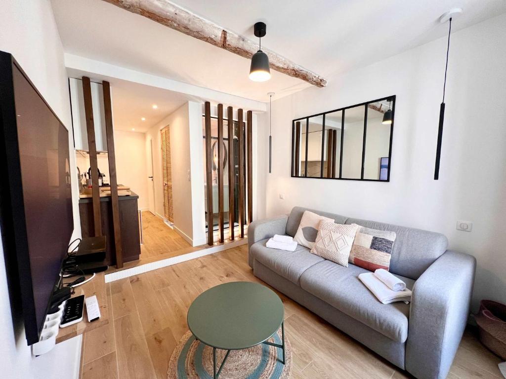 un salon avec un canapé et une télévision dans l'établissement B066 Studio design à 5 mn de la plage, à Cannes