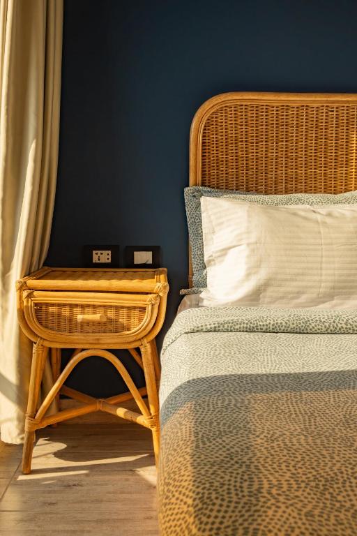 a bedroom with a rattan bed and a side table at Jimmy Pyramids Hotel in Cairo
