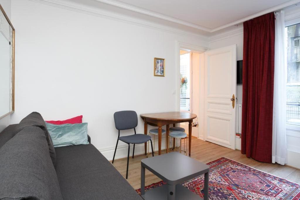 un salon avec un canapé et une table dans l'établissement Cosy Flat 30m2 Paris Centre, à Paris
