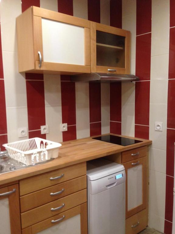 a kitchen with wooden cabinets and a dishwasher at Villa Boston in La Bourboule