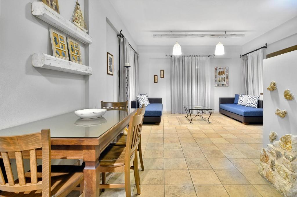a dining room and living room with a table and chairs at Niriides Luxury Apartments in Syvota