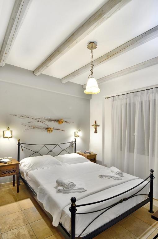 a bedroom with a large bed with white sheets at Niriides Luxury Apartments in Syvota