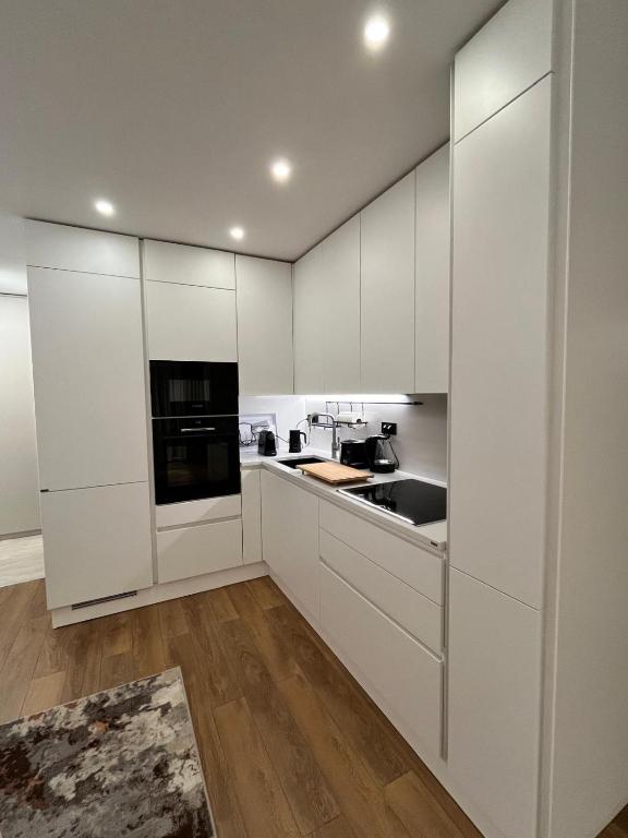 a white kitchen with white cabinets and a sink at Apartman Ingrid in Zaprešić