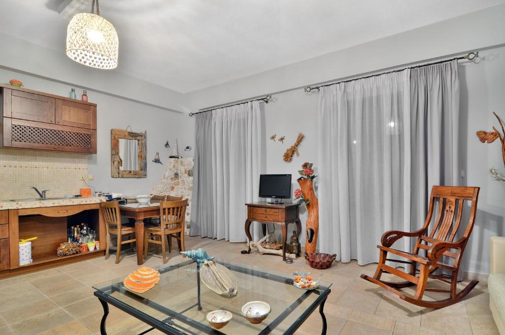 a living room with a table and a dining room at Niriides Luxury Apartments in Syvota
