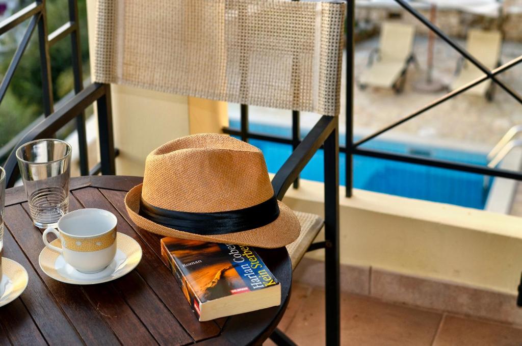 a hat sitting on a table with a cup of coffee at Niriides Luxury Apartments in Syvota