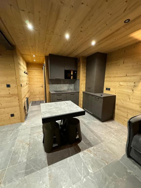 a kitchen with a table in the middle of a room at Appartement familiale Résidence Les Vans Recoin 1650 in Chamrousse
