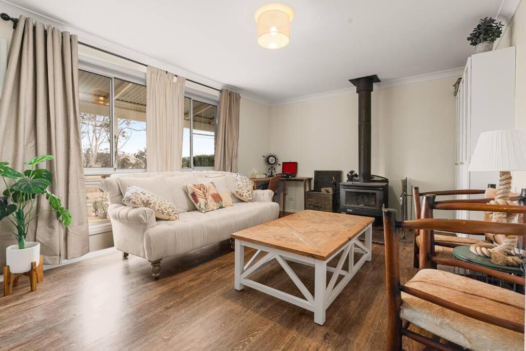 a living room with a couch and a table at Cooinda, A 3 Bedroom Home Near Mayfield Garden in Oberon