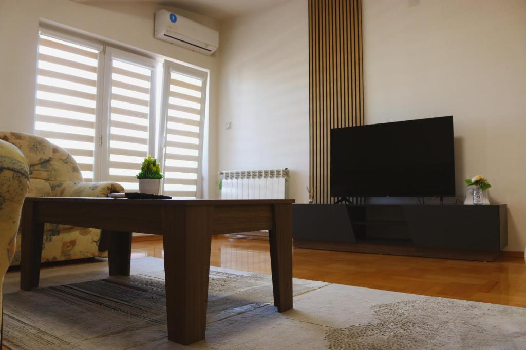Una sala de estar con una mesa de café y un televisor. en S Apartment, en Skopje