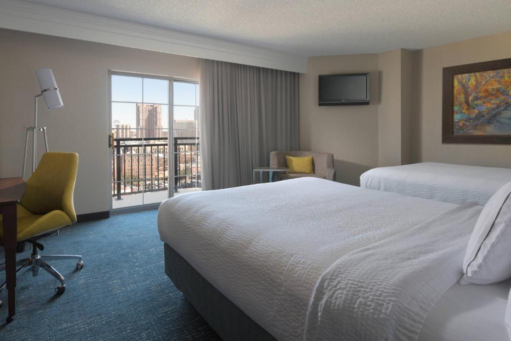 a hotel room with a bed and a desk and a window at Courtyard by Marriott San Antonio Riverwalk in San Antonio