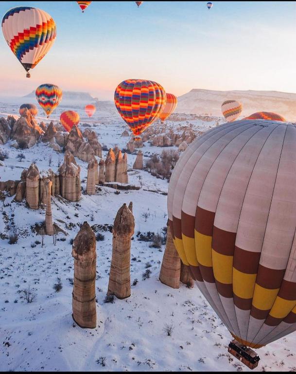 un grupo de globos de aire caliente volando sobre el desierto en Gümüş Hotel, en Ortahisar