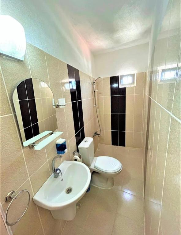a bathroom with a white toilet and a sink at Gümüş Hotel in Ortahisar