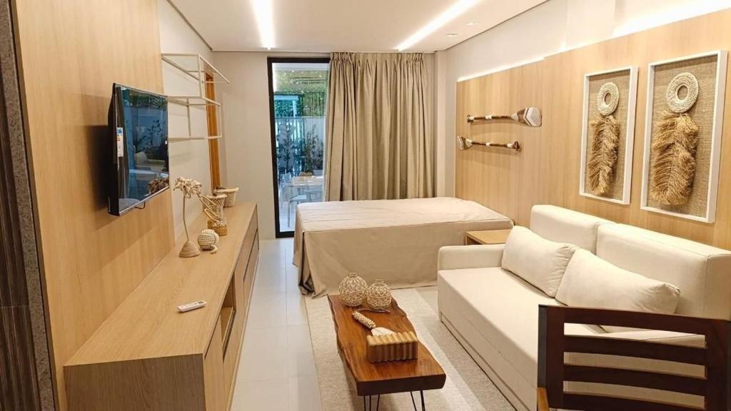 a living room with a couch and a bed at Amura - Beira mar de Carneiros in Tamandaré