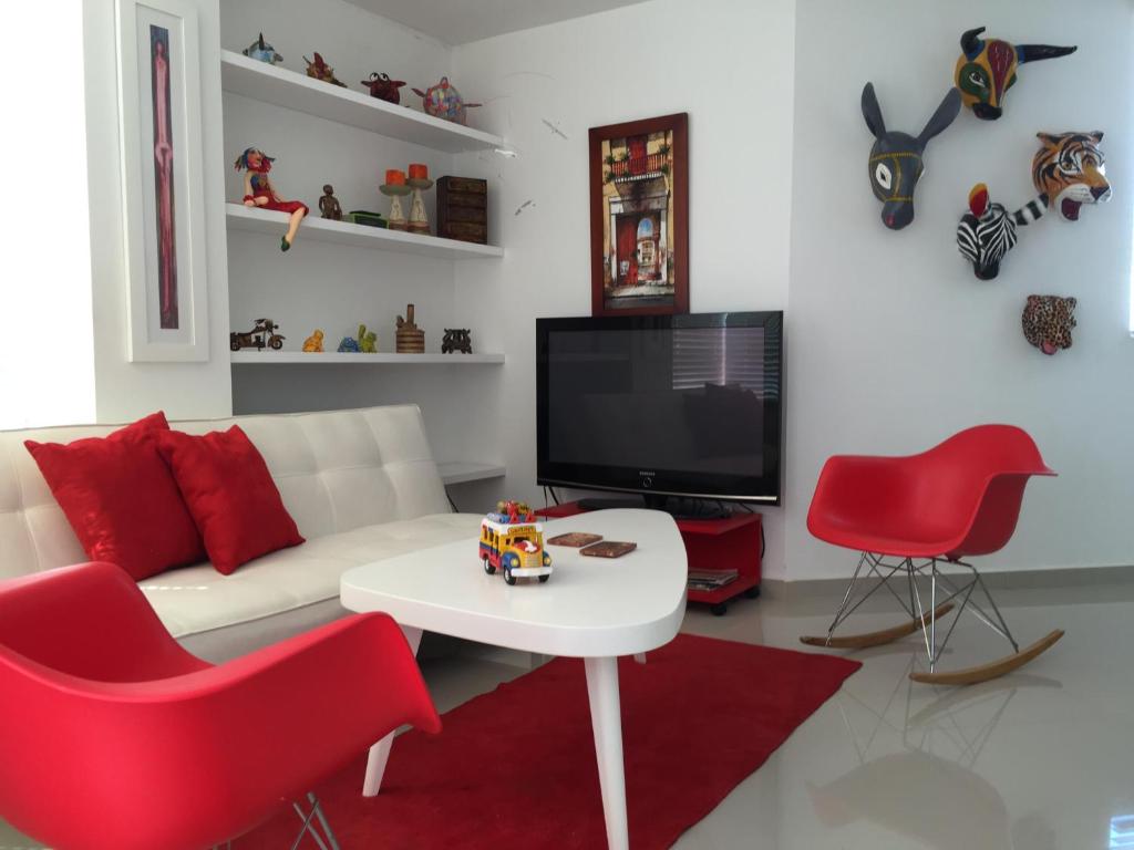 a living room with a white couch and red chairs at Apto 501 E Alto del Fonce in San Gil