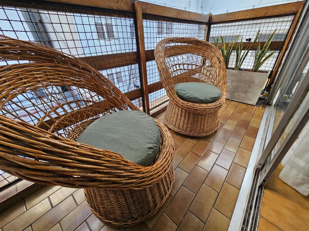 2 Korbstühle auf einem Balkon in der Unterkunft Centro de Mar del Plata in Mar del Plata