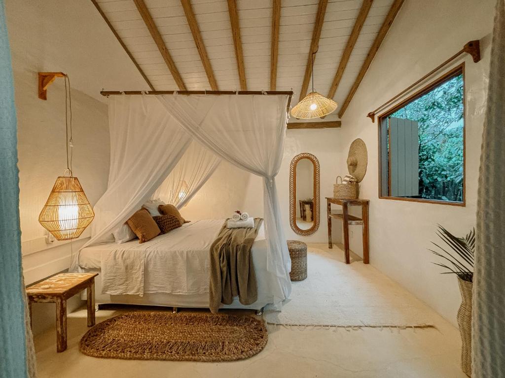 a bedroom with a bed with a canopy at Villa Prana Caraíva in Caraíva