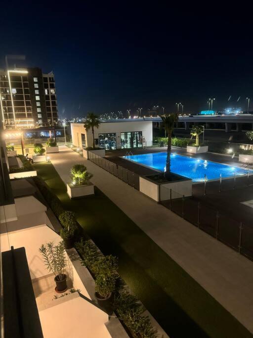 a view of a building with a swimming pool at night at The Perfect Couples Nest in Dubai