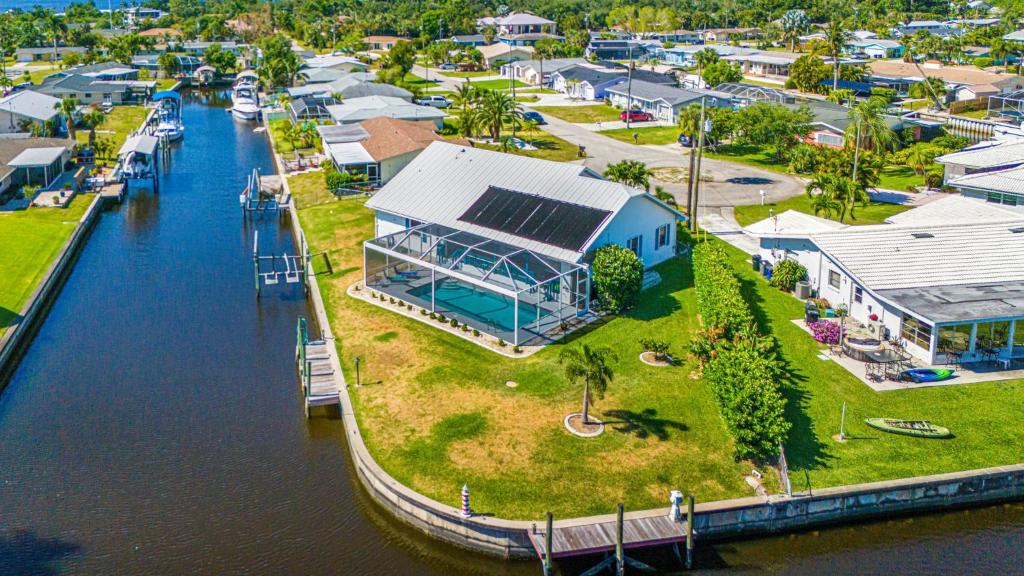 北迈尔斯堡Lazy Palm Retreat Heated Pool Jacuzzi Gulf Canal的带有房屋的码头的鸟瞰图