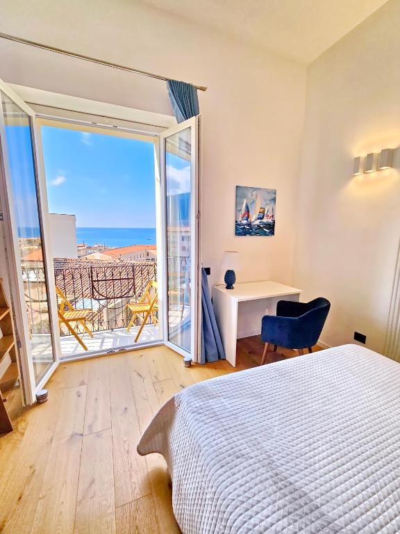 a bedroom with a bed and a desk and a window at Amunì - Exclusive Suite in Centro a Cefalù Vista Mare by CEFALU BIZ in Cefalù
