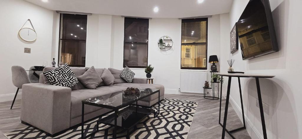 a living room with a couch and a table at Abbey Corner By Nivaas-Located in the heart of the city centre-5 minute walk to train station-20 minutes to London via train in Reading