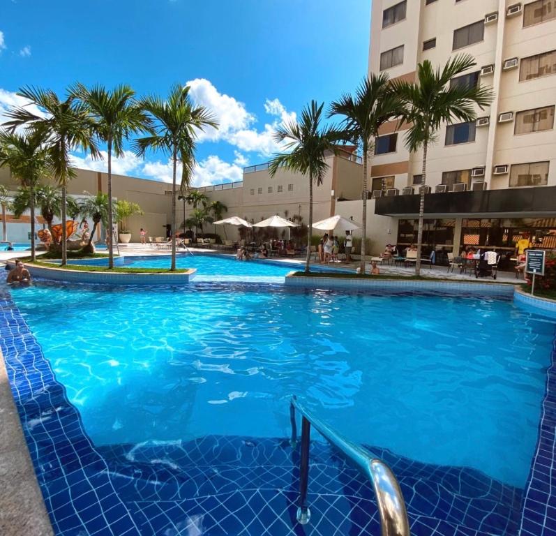 a large swimming pool with palm trees in a hotel at Hotel boulevard caldas novas in Caldas Novas