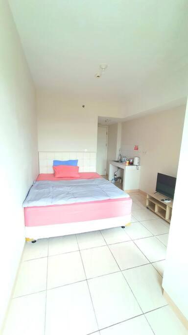 Postel nebo postele na pokoji v ubytování summarecon springlake view