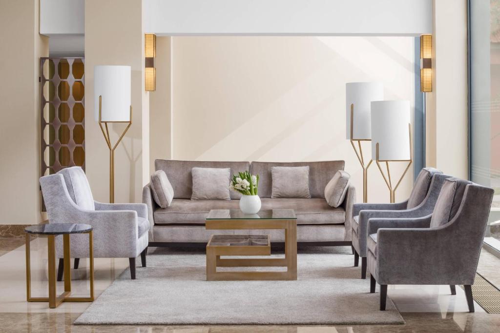 a living room with a couch and two chairs and a table at Sheraton Cascais Resort - Hotel & Residences in Cascais