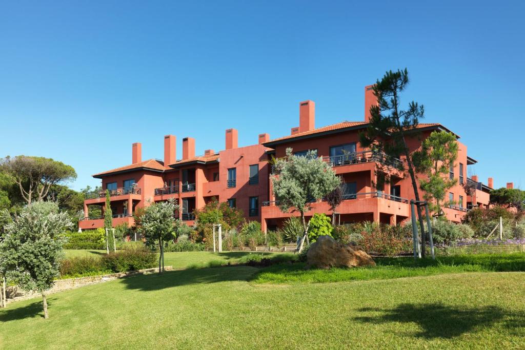 an apartment building with a lawn in front of it at Sheraton Cascais Resort - Hotel & Residences in Cascais