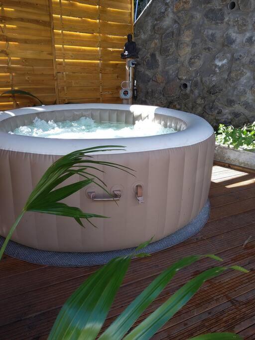 a jacuzzi tub sitting on a wooden floor at charmante maison in Les Avirons