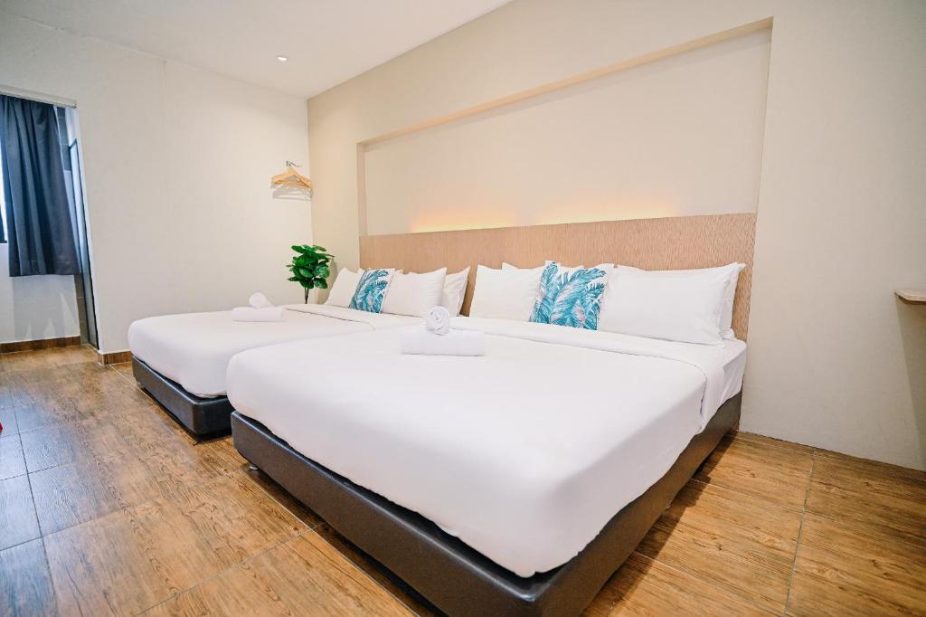 two large white beds in a room at Swing & Pillows - KL Sri Petaling in Kuala Lumpur