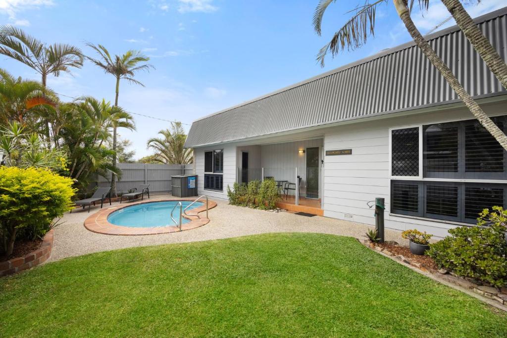 a backyard with a swimming pool and a house at Allamanda Sands in Peregian Beach