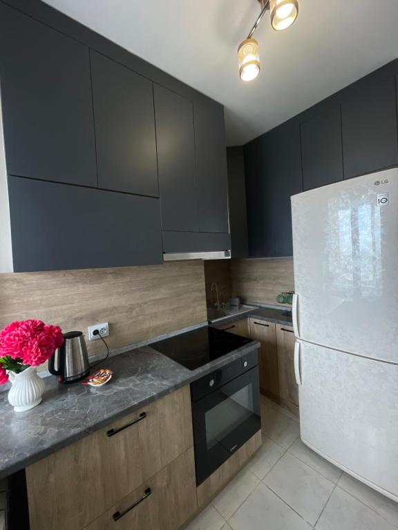 a kitchen with black cabinets and a white refrigerator at Самрук Towers,жилой комплекс in Taldykolʼ