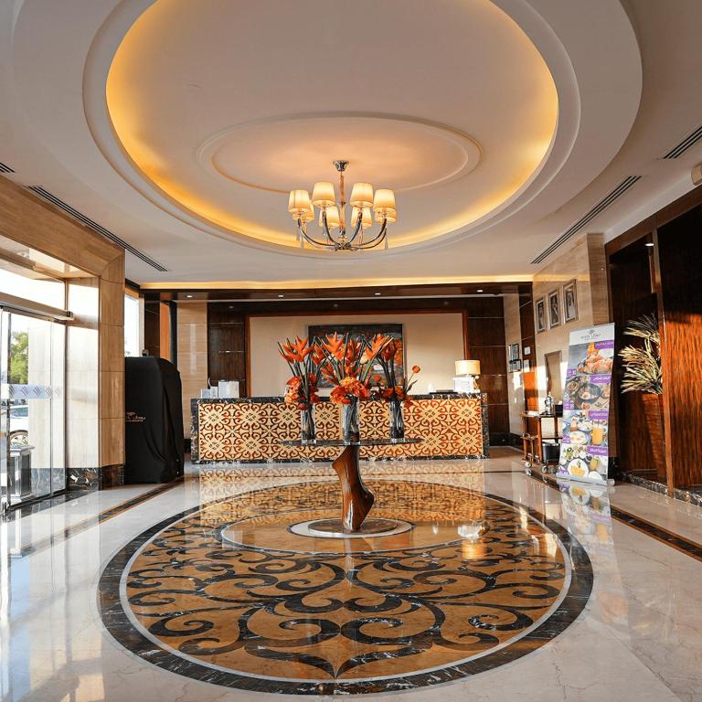 a lobby with a vase of flowers on the floor at Boudl Al Majmaa in Al Majma'ah