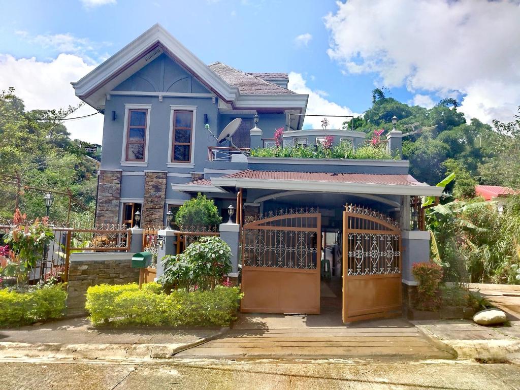 a blue house with a gate in front of it at Baguio Transient Whole House in Baguio