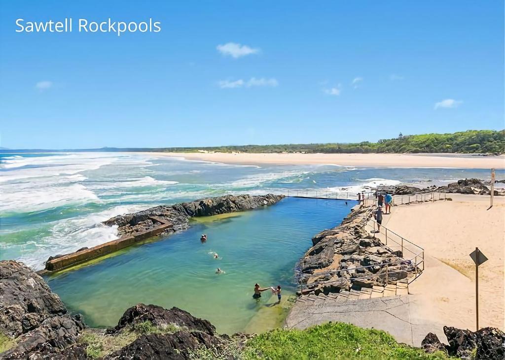 a group of people swimming in a pool on a beach at Banksia in Sawtell
