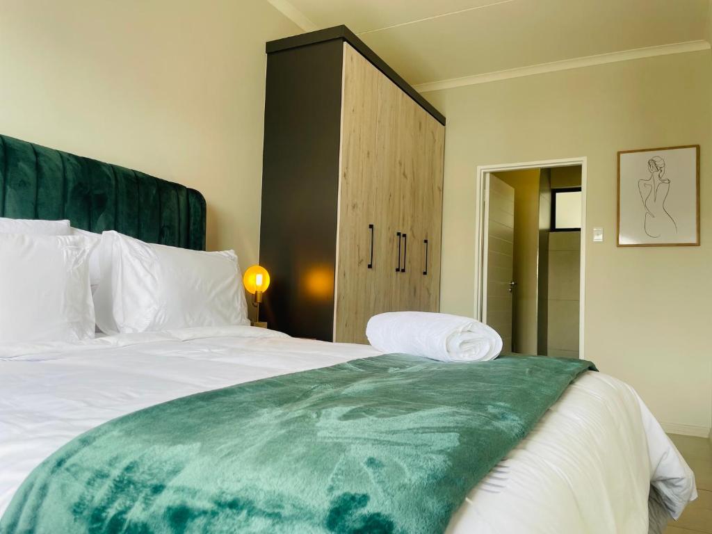 une chambre avec un grand lit et une armoire dans l'établissement Mikeys place On New: 2bed2bath no.1 with Free WiFiNetflix, à Midrand