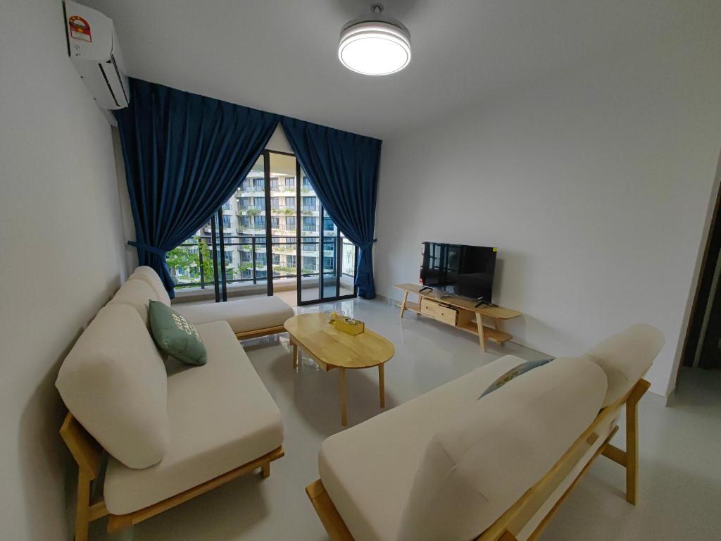 a living room with white furniture and a large window at XTU 3Bedrooms at Forest City in Kampong Pok Kechil