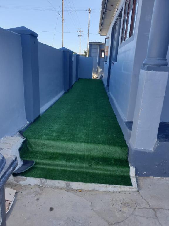 a room with a green floor next to a building at PEACE LODGE in Cape Town